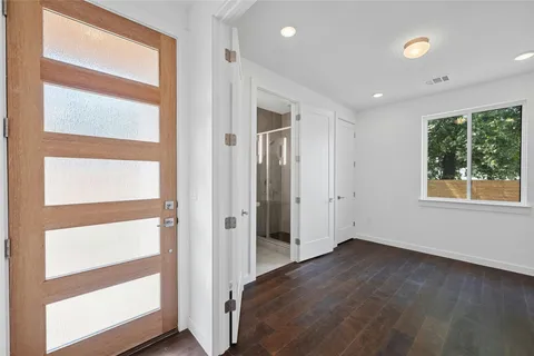 a view of a hallway with wooden floor and windows