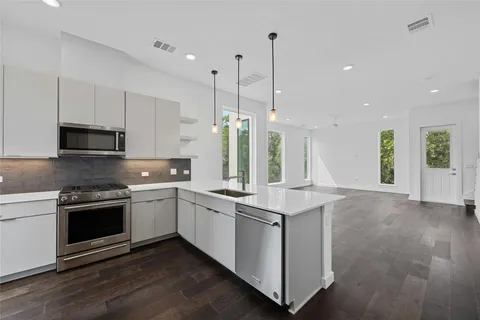 a kitchen with stainless steel appliances granite countertop a sink and stove top oven