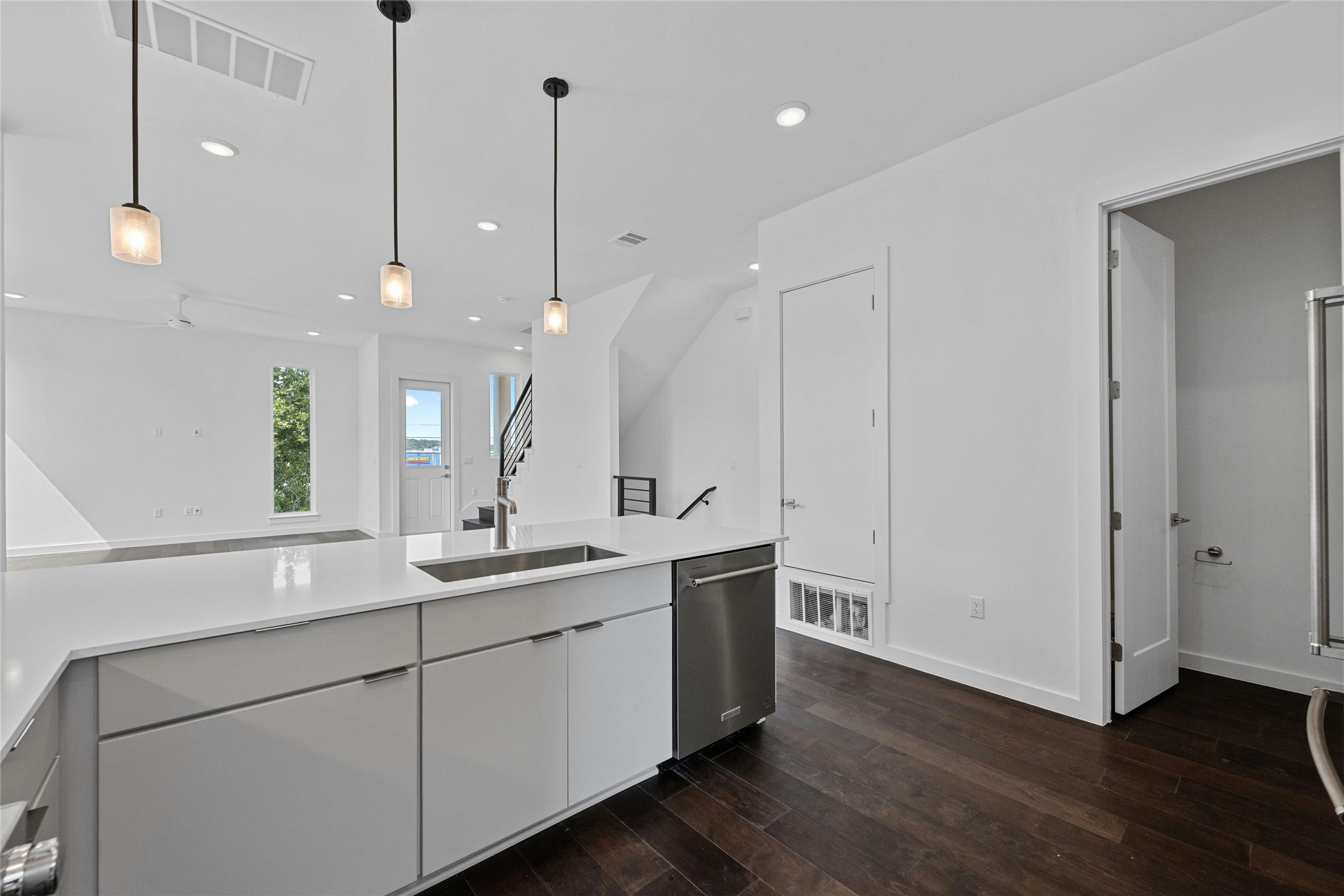 6825 Wolfcreek Pass, Unit 2 Austin, TX 78749 - Photo 10 of 34 a kitchen with a sink chandelier and wooden floor