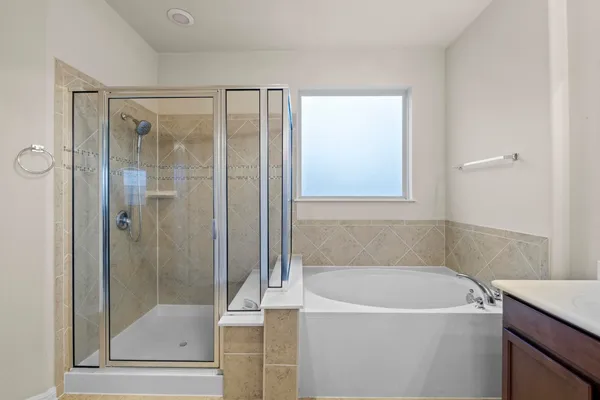 a spacious bathroom with a tub shower and a sink