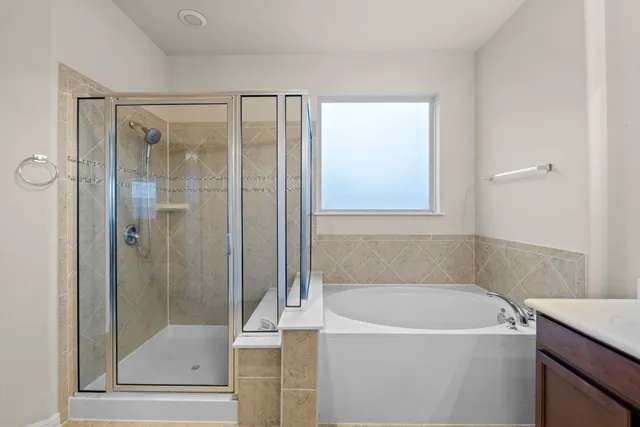 a spacious bathroom with a tub shower and a sink