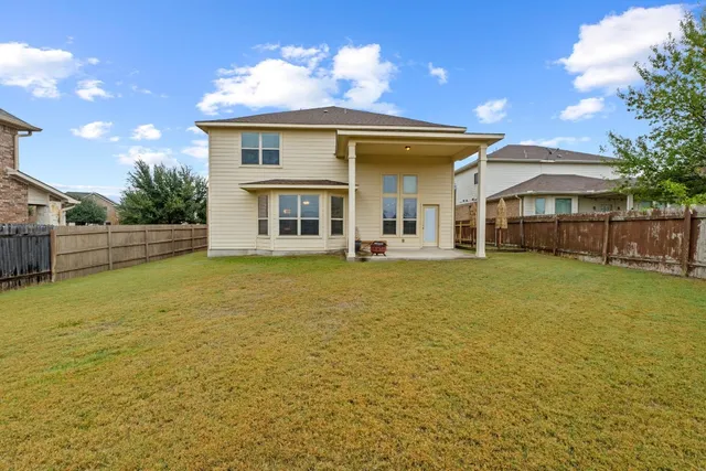 a view of a house with a backyard and a tree