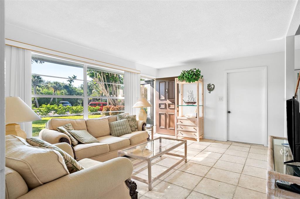 597 Sutton Place Longboat Key, FL 34228 - Photo 12 of 49 a living room with furniture and a flat screen tv