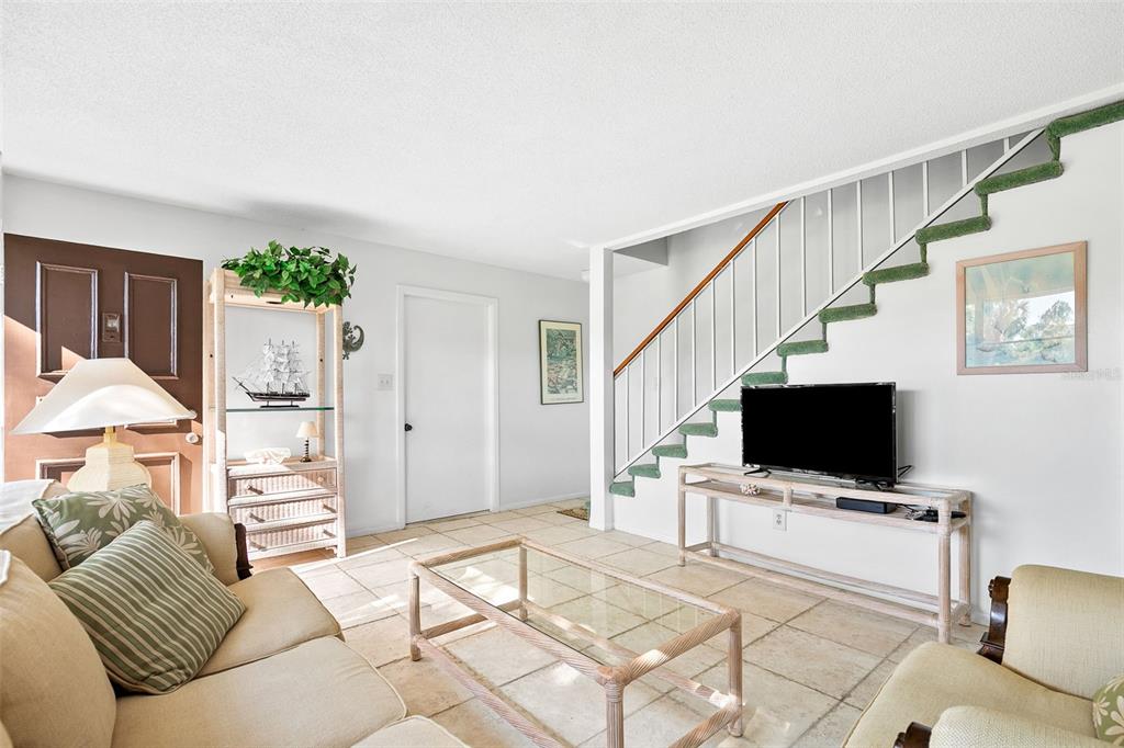 597 Sutton Place Longboat Key, FL 34228 - Photo 2 of 49 a living room with furniture and a flat screen tv