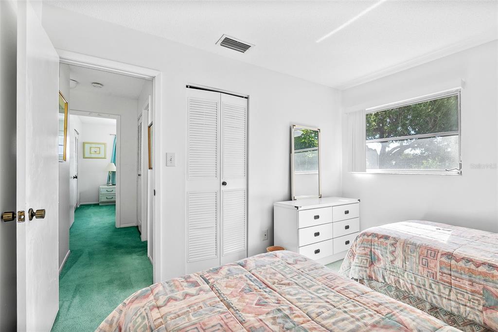 597 Sutton Place Longboat Key, FL 34228 - Photo 21 of 49 a bedroom with a bed and a window