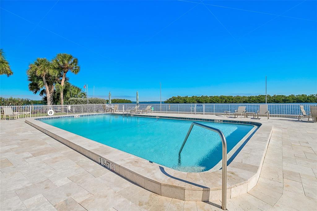 597 Sutton Place Longboat Key, FL 34228 - Photo 27 of 49 a view of a swimming pool with a lounge chair