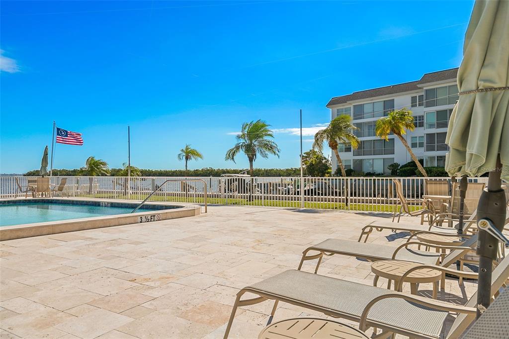 597 Sutton Place Longboat Key, FL 34228 - Photo 28 of 49 a view of a swimming pool with a lounge chairs