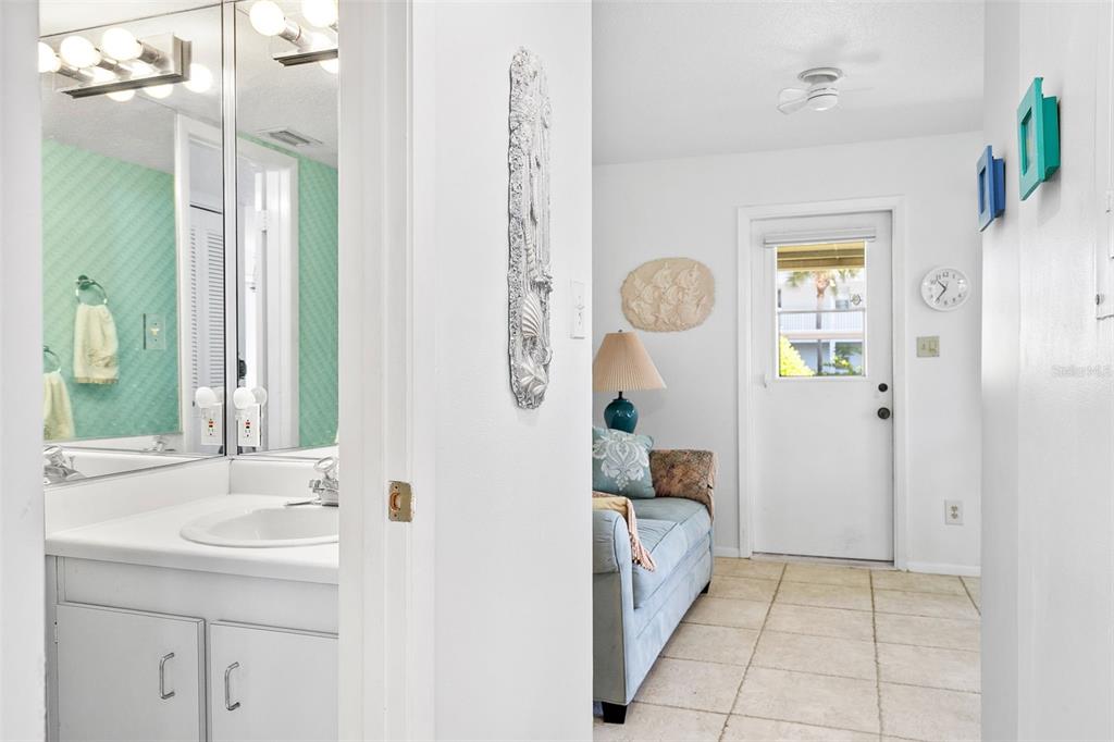 597 Sutton Place Longboat Key, FL 34228 - Photo 3 of 49 a bathroom with a sink a mirror and a shower