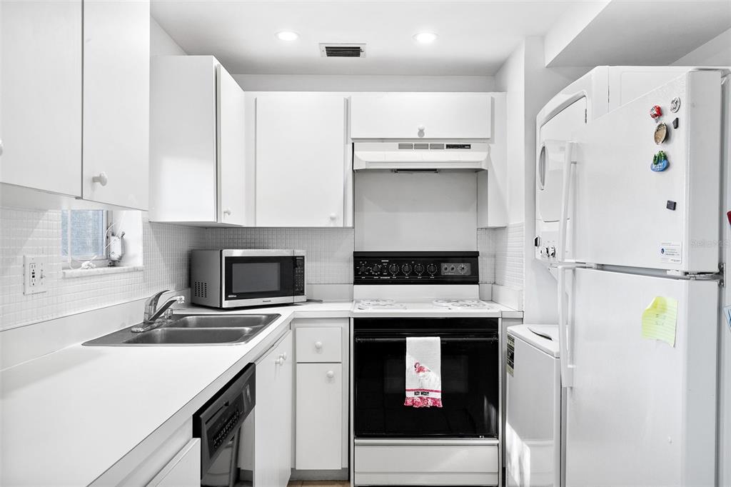 597 Sutton Place Longboat Key, FL 34228 - Photo 6 of 49 a kitchen with a sink a stove and a refrigerator