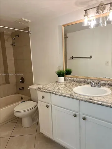 a bathroom with a granite countertop toilet a sink and a mirror