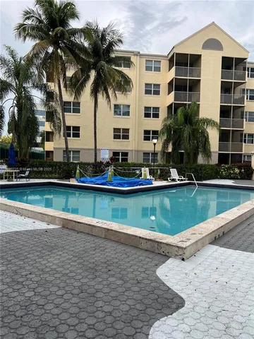 a view of swimming pool with a yard and large trees