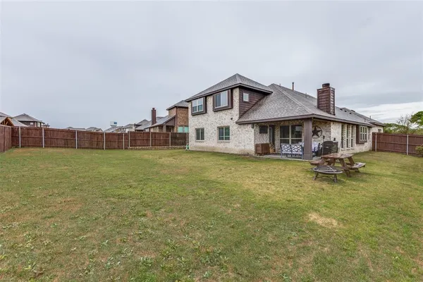 a view of a house with a big yard and sitting area