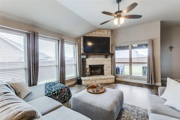 a living room with furniture a flat screen tv and a fireplace