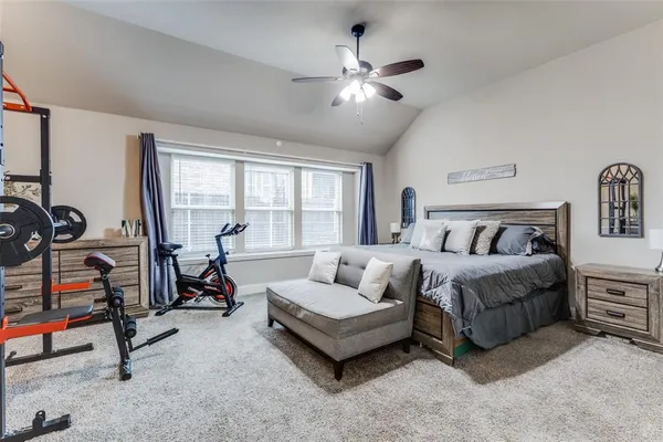 a spacious bedroom with a bed a couch and a chandelier