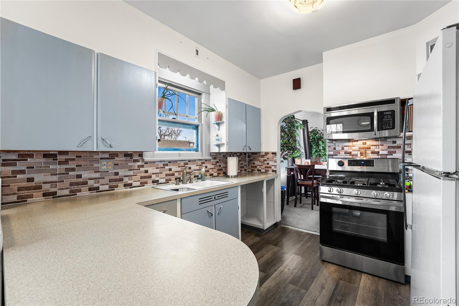 6145 West 38th Avenue Wheat Ridge, CO 80033 - Photo 12 of 39 a kitchen with stainless steel appliances a stove sink and microwave