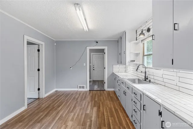 a spacious bathroom with a granite countertop sink a mirror and a bathtub