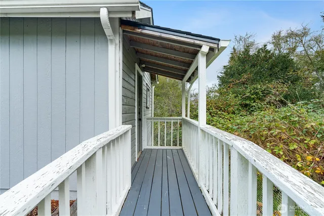 a view of a balcony with wooden floor and fence