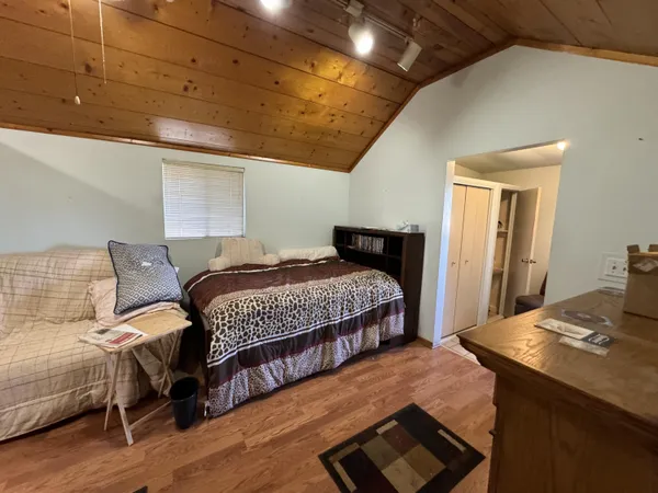 a bedroom with a bed and wooden floor