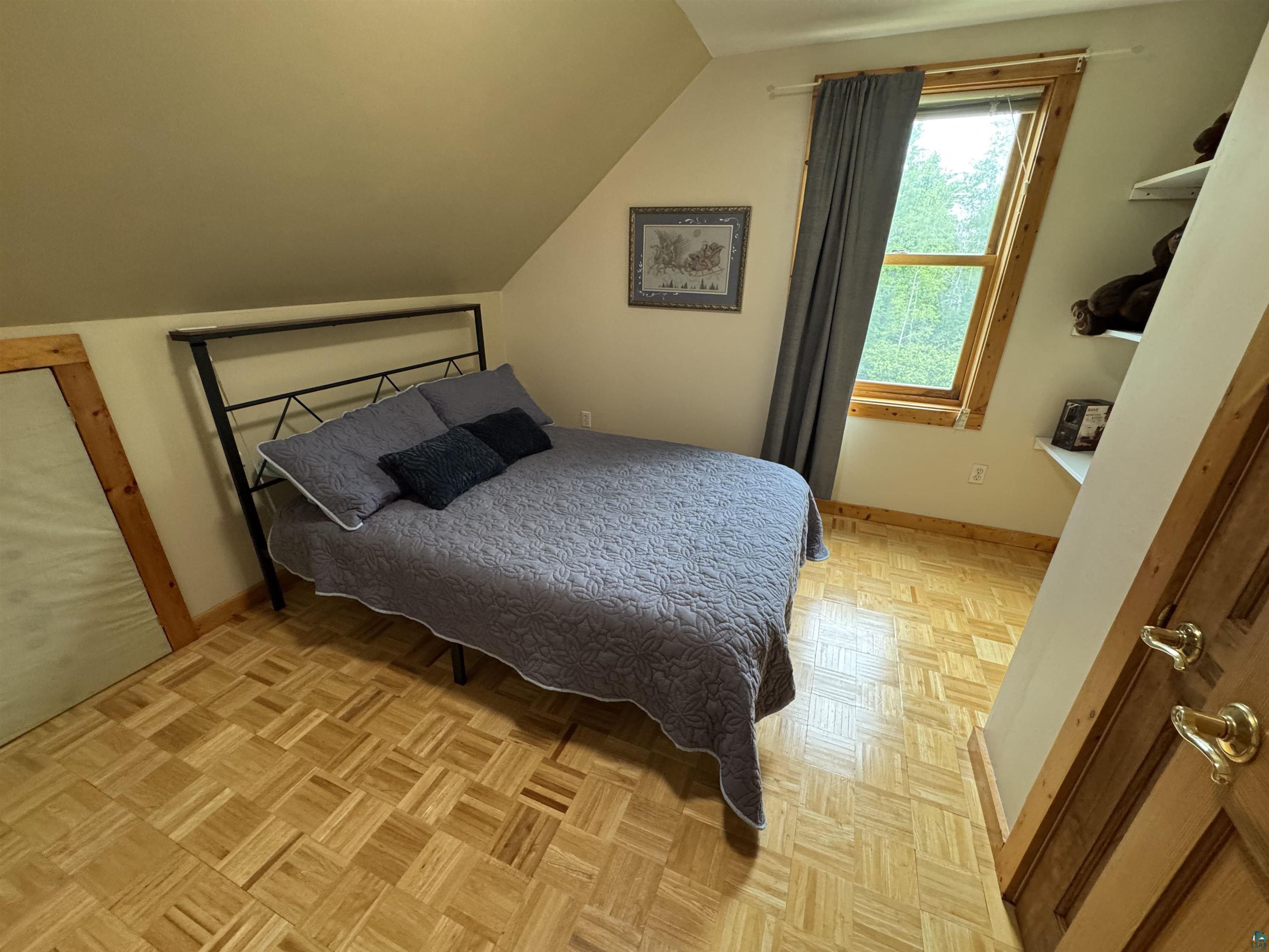 1745 Becks Road Maple, WI 54854 - Photo 23 of 46 Slanted ceiling room featuring parquet wood flooring, wood-framed window, and built-in shelving