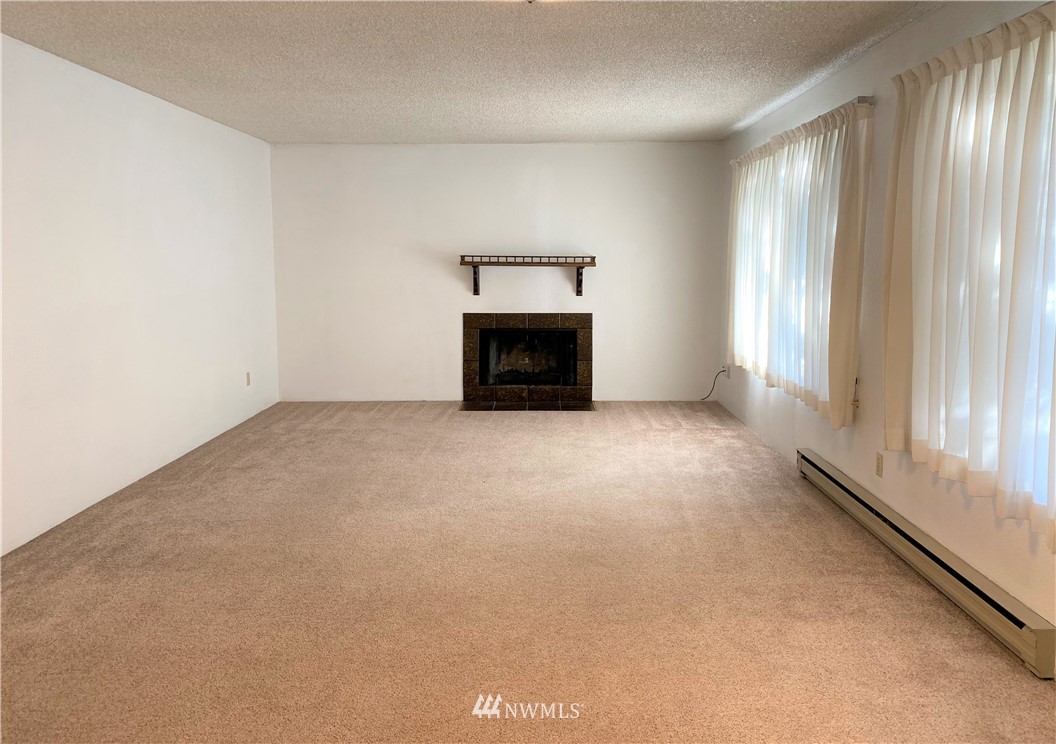 an empty room with a fireplace and window