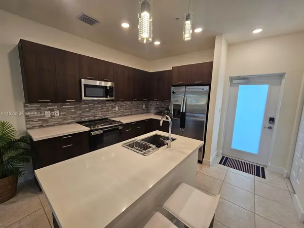 a kitchen with stainless steel appliances a refrigerator and a stove top oven