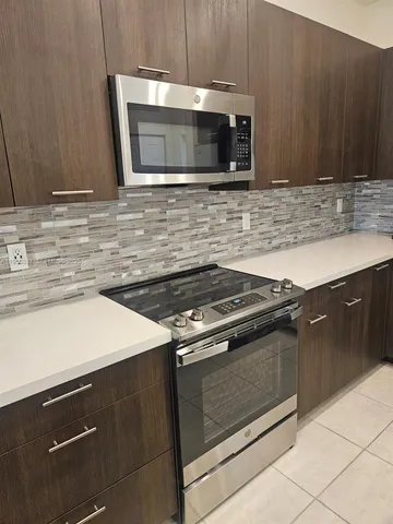 a kitchen with granite countertop a stove microwave and sink