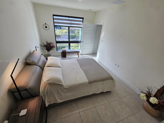 a bedroom with a bed window and couch