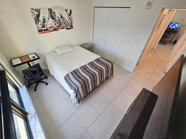 a bedroom with a bed and a painting on the wall