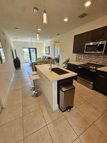 a kitchen with a sink and a stove top oven with wooden floor