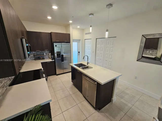 a kitchen with a stove a refrigerator and a sink