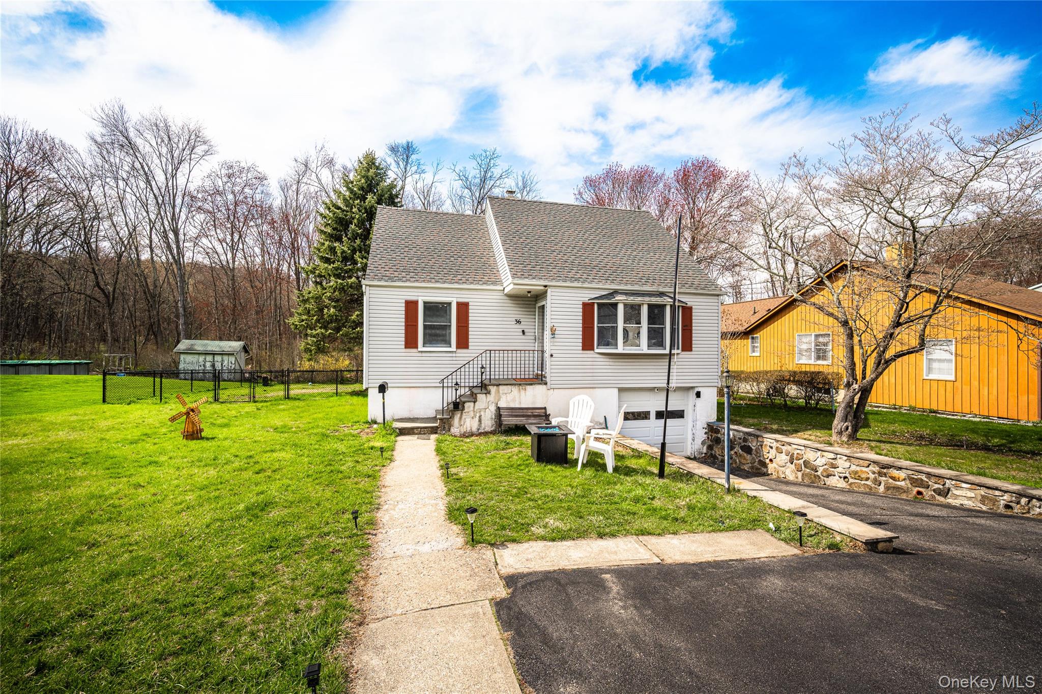 Charming front exterior featuring a private driveway, attached garage, and welcoming entryway with mature landscaping.