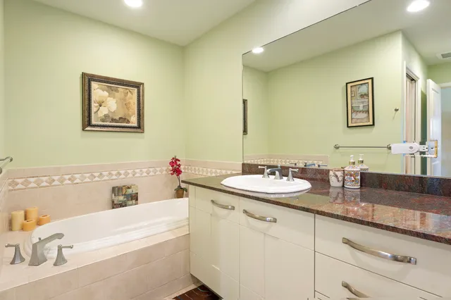 a bathroom with a tub sink and mirror
