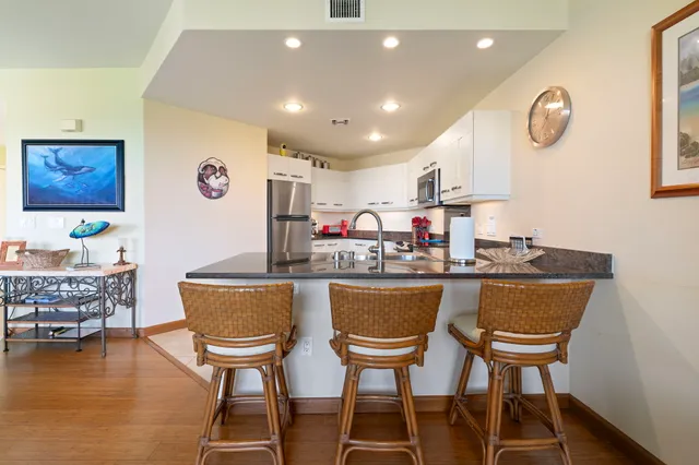 a dining hall with stainless steel appliances a dining table and chairs with wooden floor