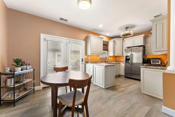 a kitchen with a table chairs and a refrigerator
