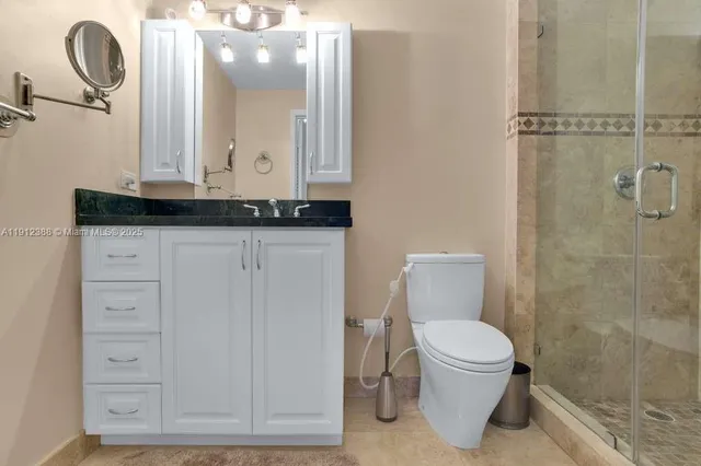 a bathroom with a granite countertop toilet a sink and mirror