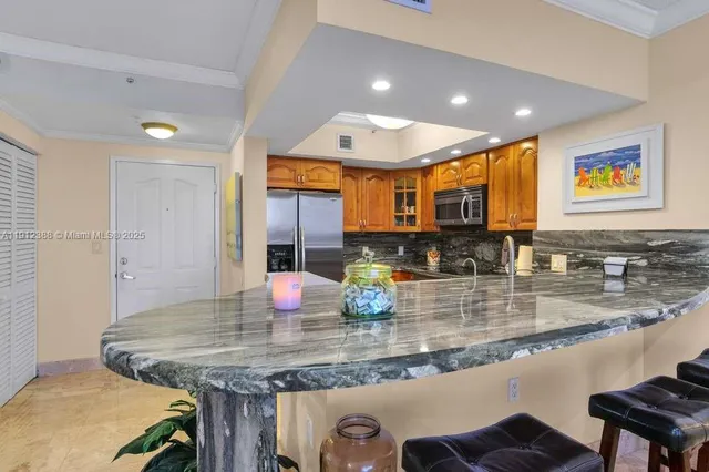a kitchen with kitchen island granite countertop a table and chairs in it