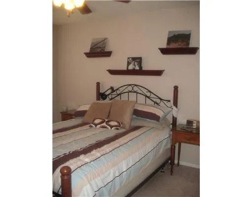 a bed sitting in a bedroom next to a bathroom with a sink