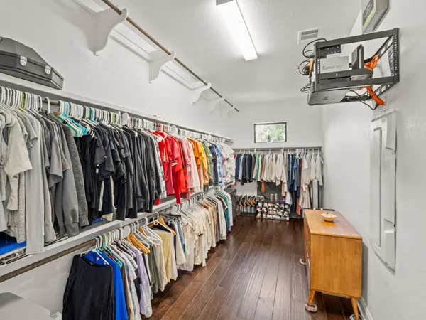 a view of walk in closet with clothes and shoes