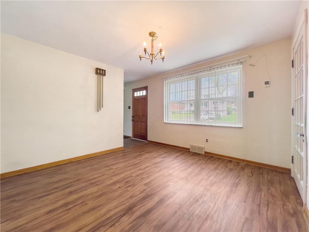 2023 Spring Hill Road Pittsburgh, PA 15243 - Photo 4 of 20 an empty room with wooden floor chandelier and windows