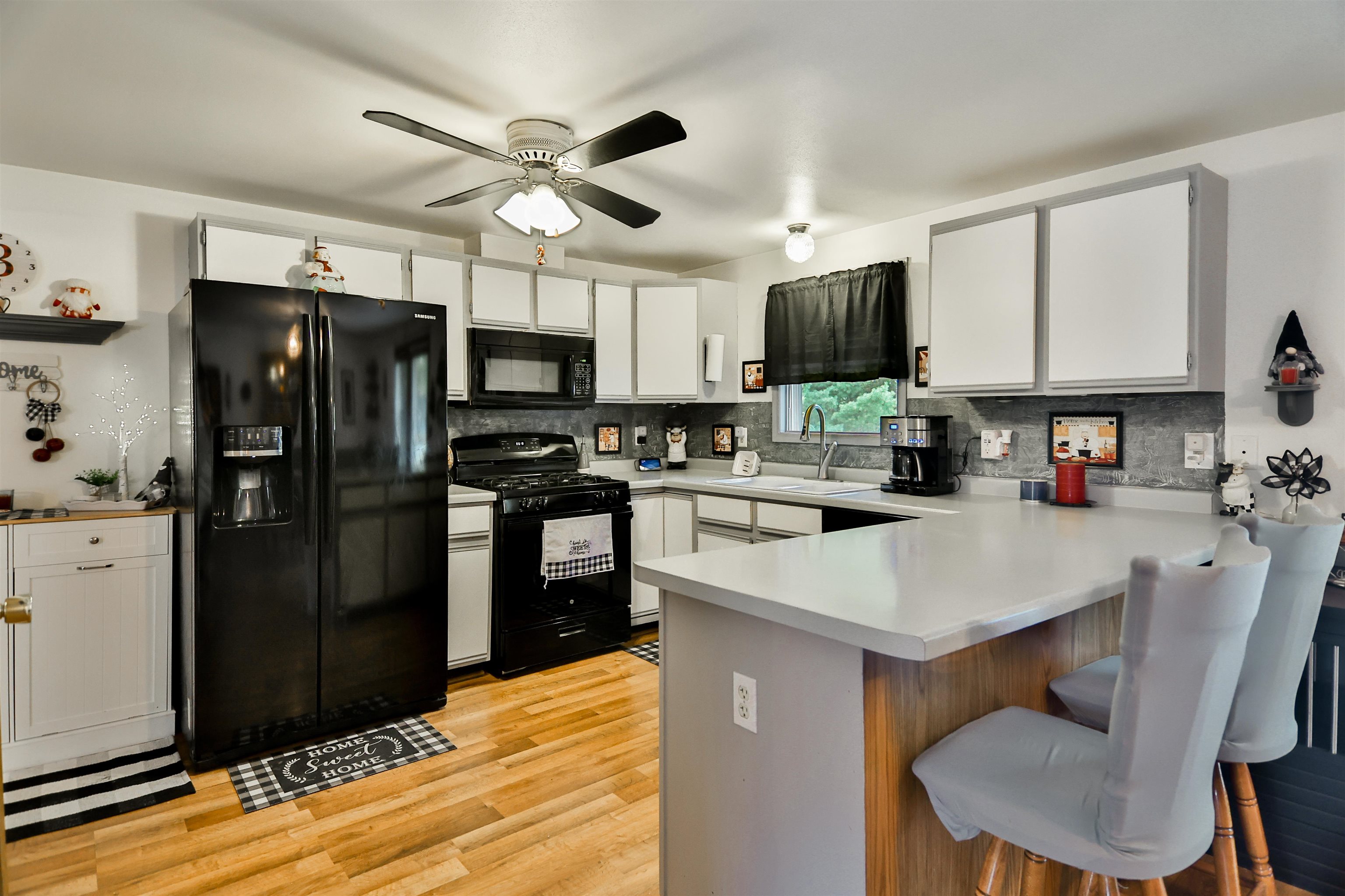 155 Lamplighter Loop Southeast Poplar Grove, IL 61065 - Photo 7 of 31 a kitchen with stainless steel appliances granite countertop a refrigerator a stove a microwave oven a sink dishwasher and white cabinets with wooden floor