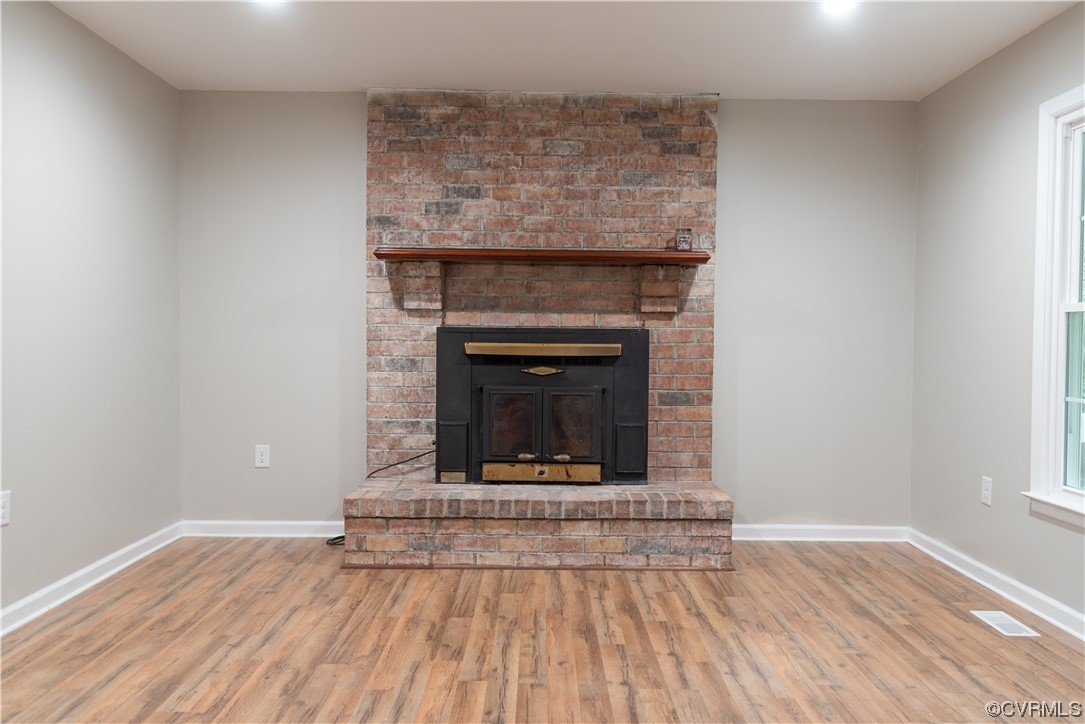 10807 Drayton Road Chester, VA 23831 - Photo 4 of 32 a living room with a fireplace and wooden floor