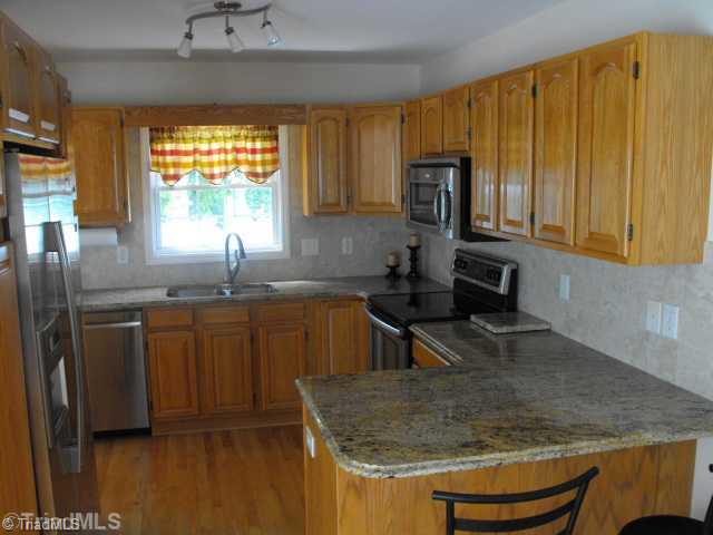 1185 Surry Line Road Pinnacle, NC 27043 - Photo 5 of 8 Kitchen. GRANITE COUNTERS, STAINLESS STEEL APPLIANCES, OAK CABINETS, SELF CLEAN CONVECTION OVEN