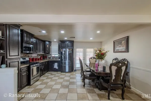 a kitchen with stainless steel appliances kitchen island granite countertop a refrigerator and a stove top oven