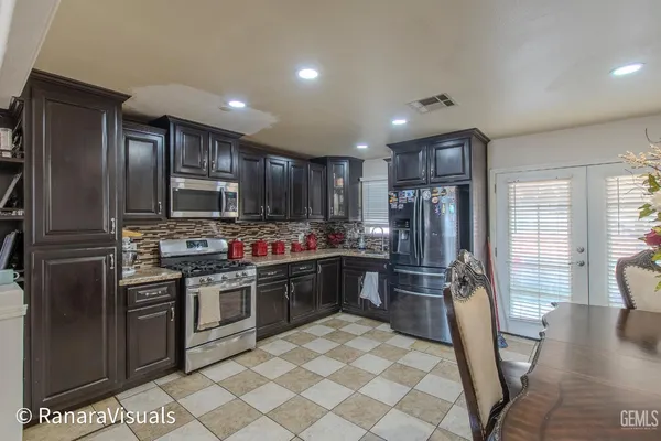 a kitchen with stainless steel appliances granite countertop a refrigerator stove top oven and sink