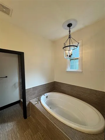 a bathroom with a bathtub and a chandelier