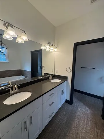 a bathroom with double vanity and a mirror