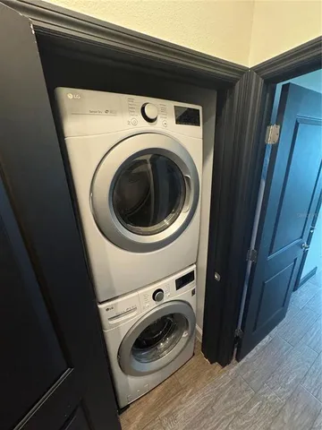an empty room with wooden floor chandelier and windows