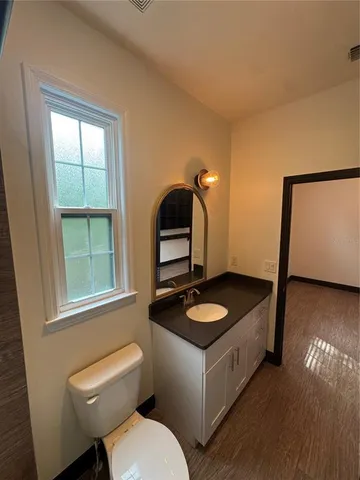 a view of empty room with wooden floor