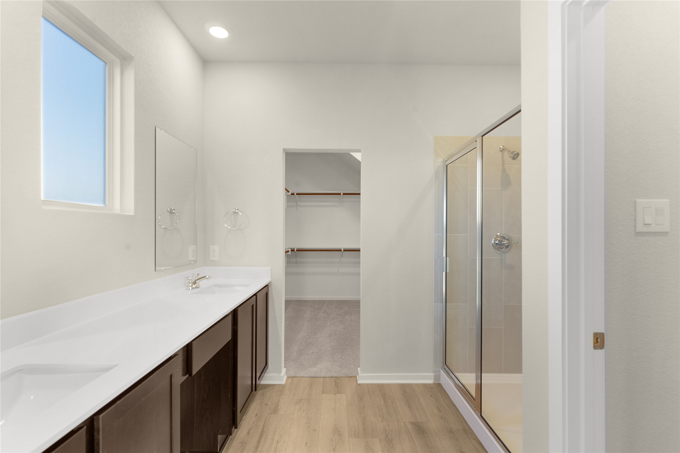 25628 Wheat Seed Lane Elgin, TX 78621 - Photo 9 of 20 Bathroom featuring a stall shower, light wood finished floors, double vanity, a spacious closet, and recessed lighting