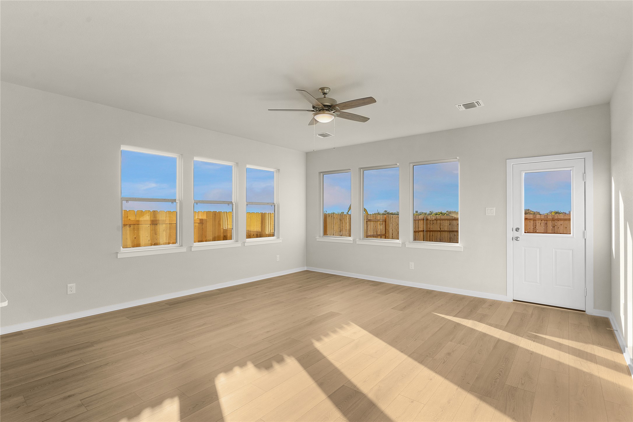 25628 Wheat Seed Lane Elgin, TX 78621 - Photo 3 of 20 Empty room with ceiling fan, light wood finished floors, and plenty of natural light